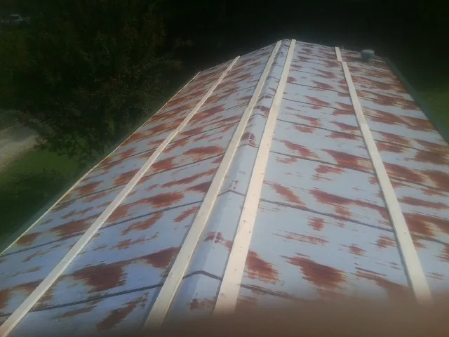 Rusted metal roof panels with new wood purlins before replacement — Storm Damage Roof Repair in Camak by Roofing Brothers