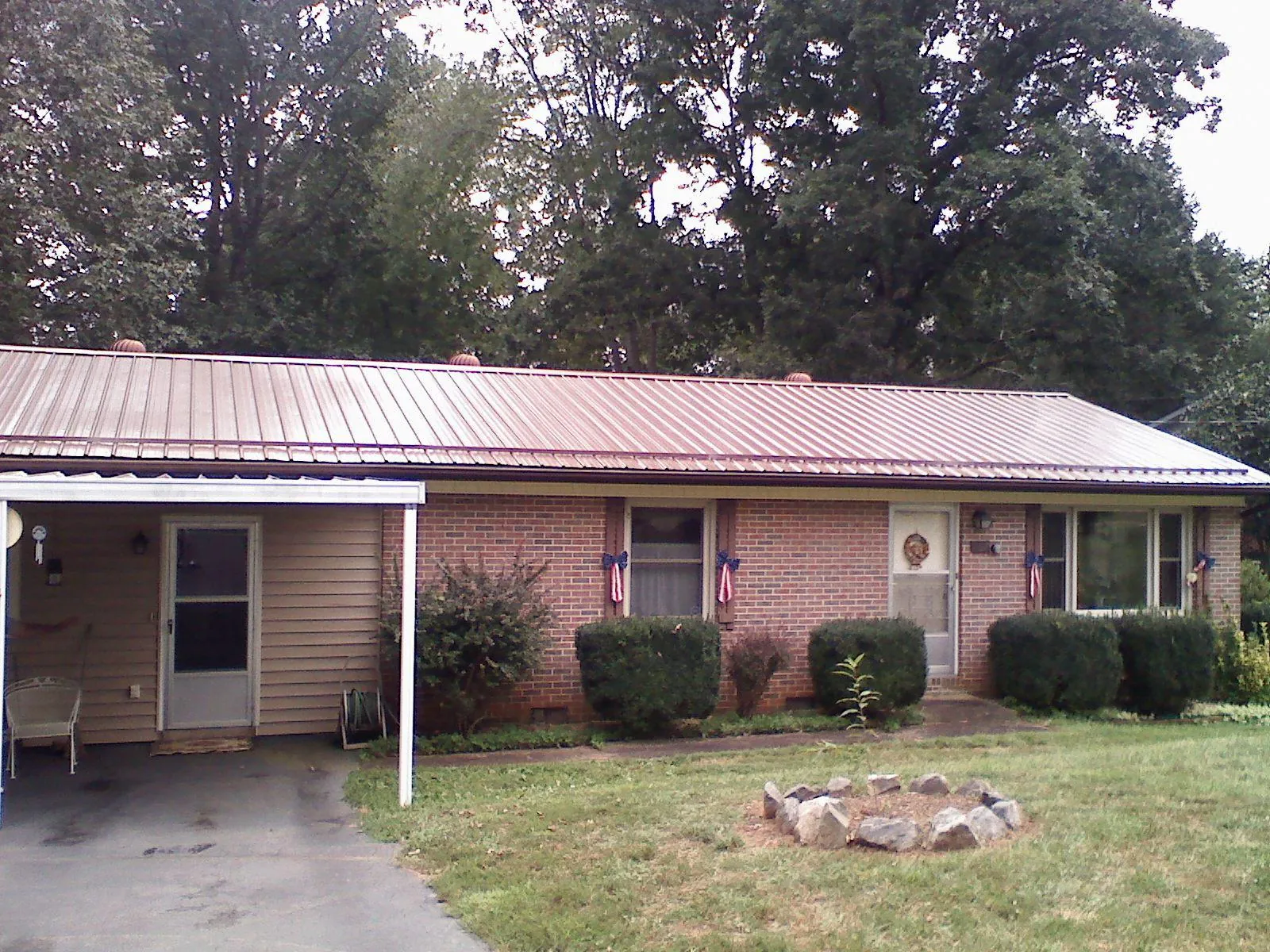 Bronze metal roof and carport on a brick ranch home — Roof Repair work by our crew in Camak